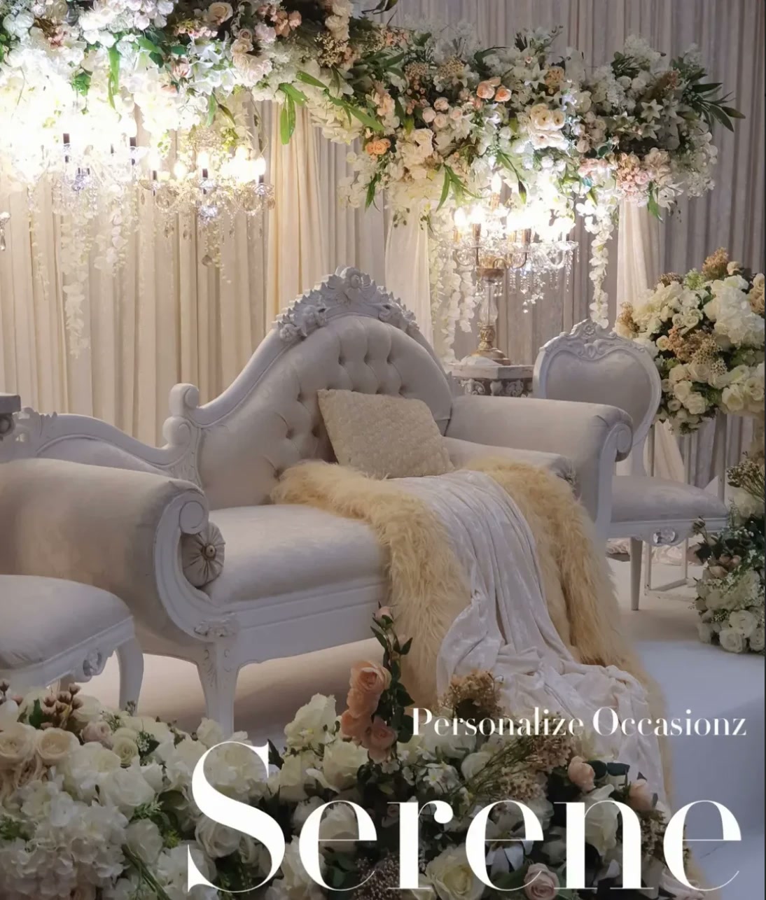 A white tufted chaise under cascading flowers and soft lights in the Serene collection.